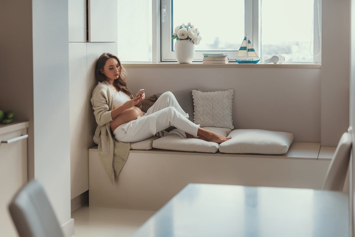 Calm pregnant mum relaxing in bright light flat